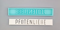 Zwei Silikonformen von Easy-Sticks, jede mit dem Schriftzug "PFOTENLIEBE" auf einer einzigartigen, kreativen Art. Perfekt für individuelle Dekorationen und Geschenke.