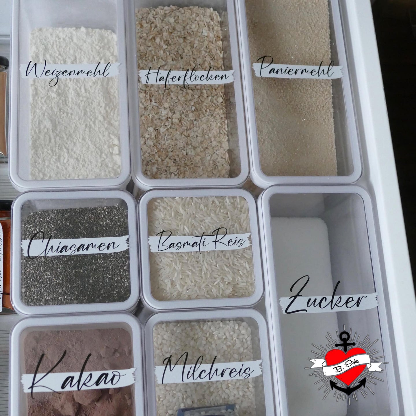 Kreative Vorratshaltung mit beschrifteten Behältern für verschiedene Lebensmittel wie Weizenmehl, Haferflocken und Zucker, designed von easy-sticks und inspiriert von der Laserdatei '138 x Vorratshaltung'. Ideale Lösung für Ihre Küchenorganisation.