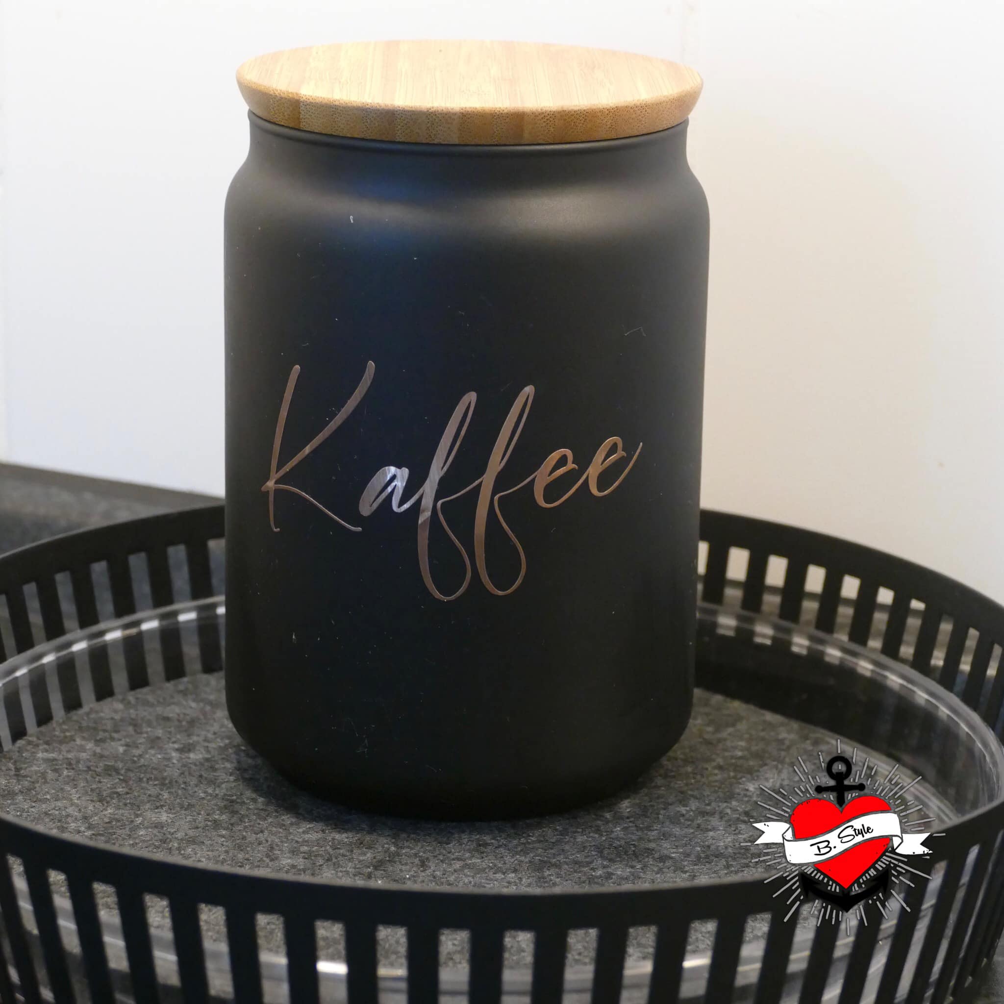 Ein stilvoller schwarzer Vorratsbehälter mit Holzkappe, beschriftet mit 'Kaffee', ideal für die Aufbewahrung von Lebensmitteln. Produkt von easy-sticks, Teil der '138 x Vorratshaltung' Laserdatei.