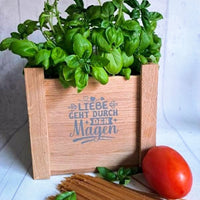Küchenkräuter im Holzbehälter mit der Aufschrift 'Liebe geht durch den Magen' - Ein inspirierendes Küchenzitat von easy-sticks, Teil des '10 Sprüche für die Küche' Pakets.