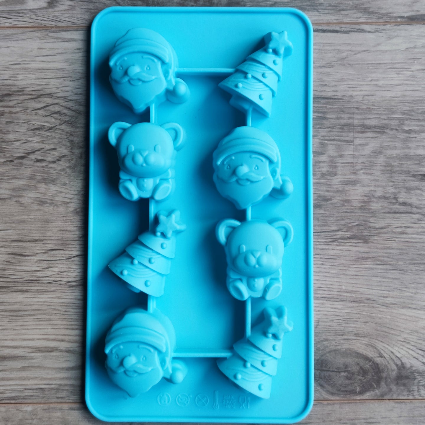 Blick auf die Silikonform kleine Weihnachtsmotive von easy-sticks, die festliche Figuren wie Santa, Tannenbaum und Bären zeigt, perfekt für kreative Weihnachtsdekorationen.