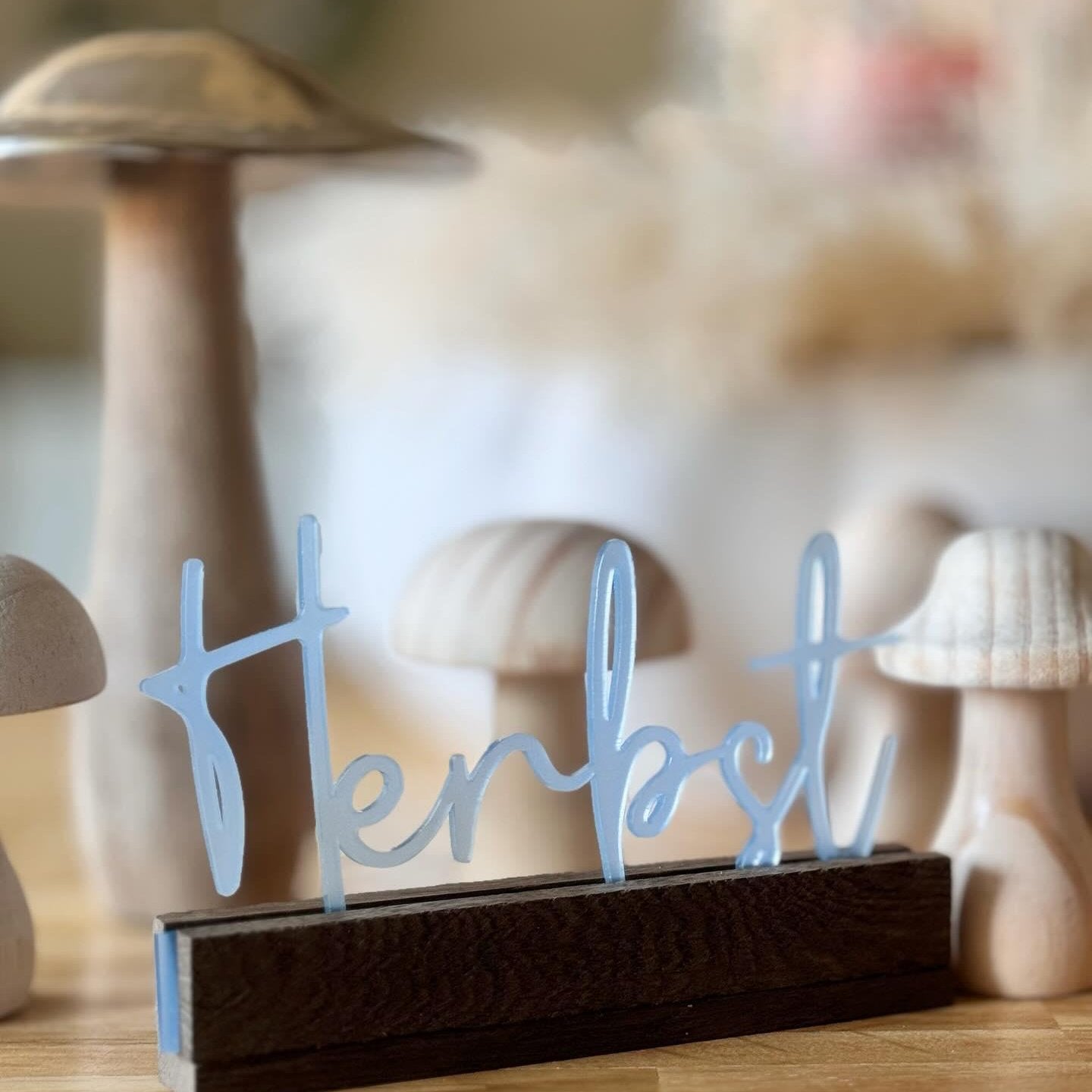 Dekorativer Herbstschriftzug von Easy-Sticks Acryl Aufsteller, umgeben von eleganten Holzpilzen auf einem Tisch.