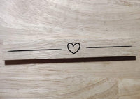 Einzigartige minimalistische Lasergravur von easy-sticks, die ein Herz auf einem Holzstück zeigt, ideal für personalisierte Geschenke oder Dekoration.