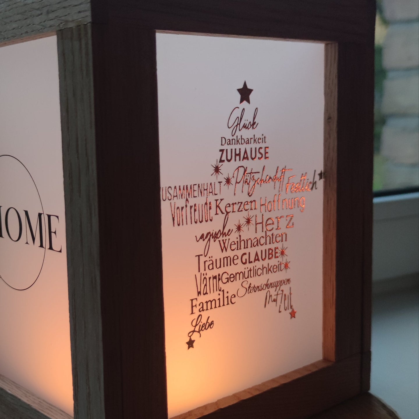 Schöne Dekoration mit dem Goldene Randlose Rub On UV Sticker von easy-sticks. Ein leuchtender Lampenschirm aus Holz zeigt die stilvollen Aufkleber mit Wörtern wie „Zuhause“ und „Glaube“, perfekt für festliche Anlässe.