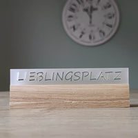 Eleganter Acryl-Easy-Stick mit dem Schriftzug 'LIEBLINGSPLATZ', von Easy-Sticks, auf einem Holzuntergrund platziert, perfekt für die dekorative Gestaltung in jedem Raum.