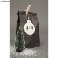 Kreative Geschenkverpackung mit Deko-Anhänger von easy-sticks, Silikon-Gießform, zeigt stilisierte Tannenbäume in weiß und gold, umgeben von Kunstschnee.