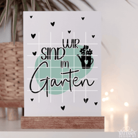 Schöne "Wir sind im Garten" Karte von easy-sticks zum Downloaden und Ausdrucken, mit einem kreativen Design und einem Blumen-Topf im Hintergrund, ideal für Gartenpartys.