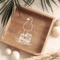 Holztablett mit stilisiertem Möwenmotiv, das auf einem Holzstamm steht, illustriert von easy-sticks, inspiriert von maritimen Plotter- und Laserdateien.