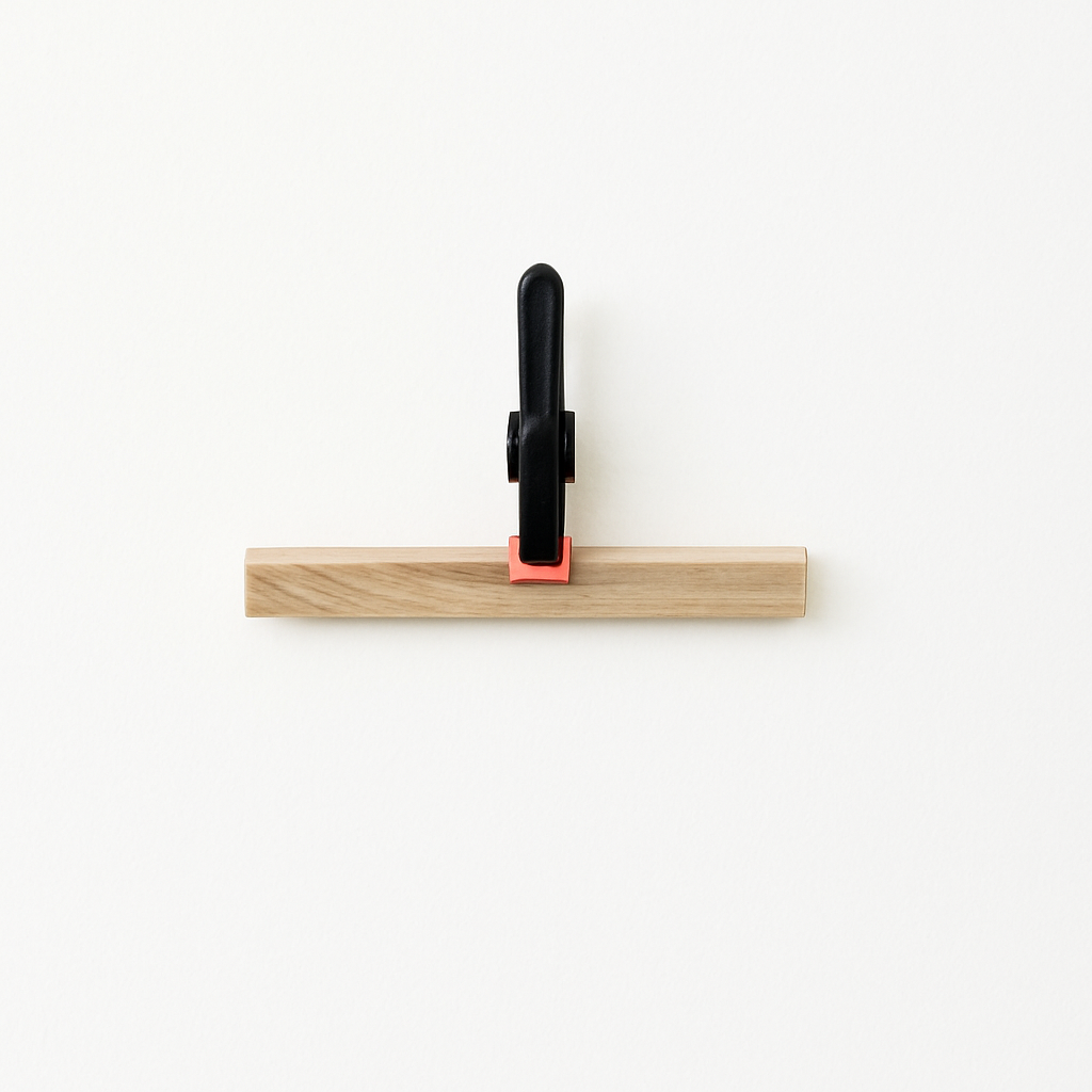 Federzwinge von Easy-Sticks auf Holzstück, ideal für präzises Halten in der Holzbearbeitung. Leichte und kompakte Konstruktion für verschiedene Materialstärken.