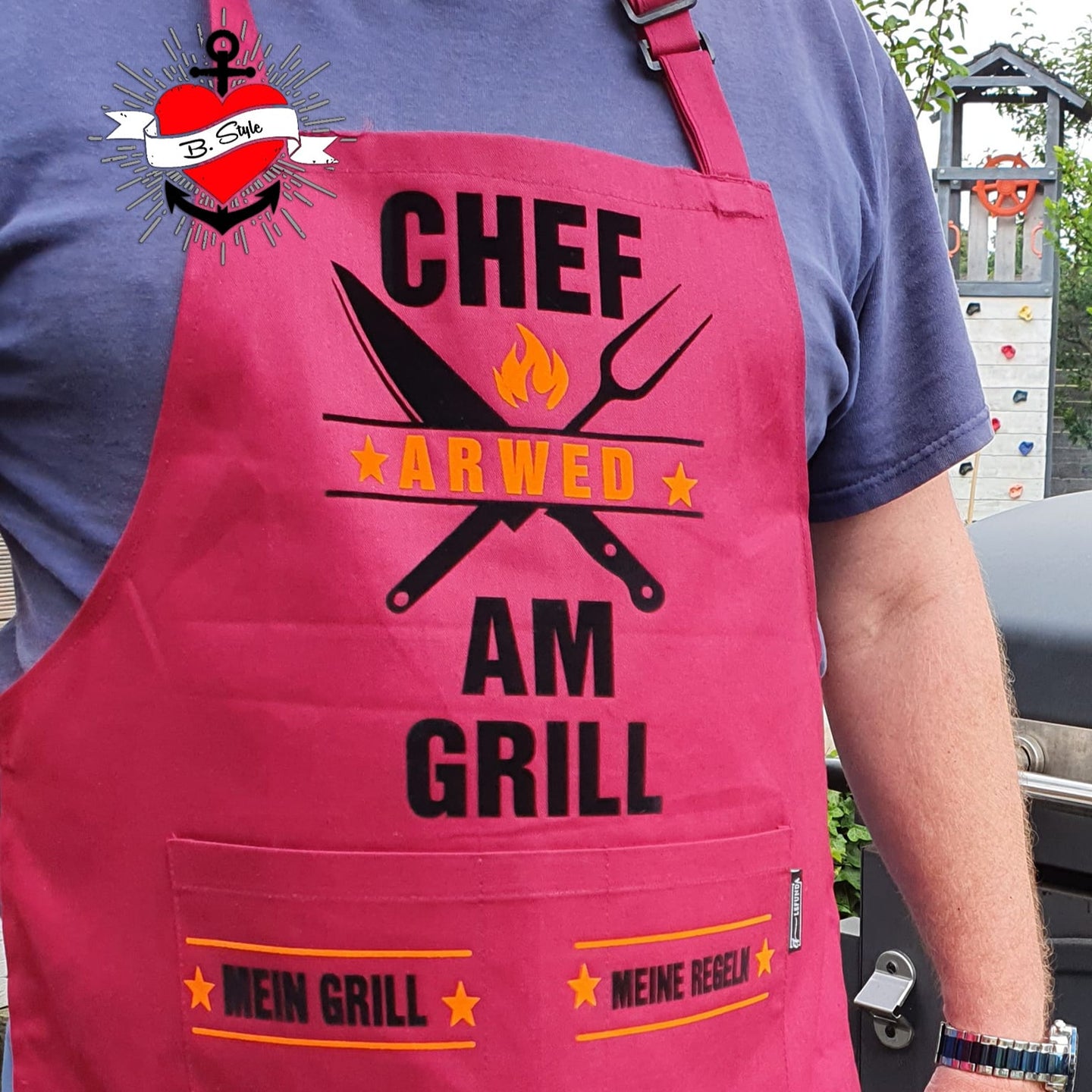 Ein rotes Grill-Schürze mit dem Design 'Chef am Grill' von easy-sticks, perfekt für Grillliebhaber, die ihre Leidenschaft für das Grillen zeigen möchten.