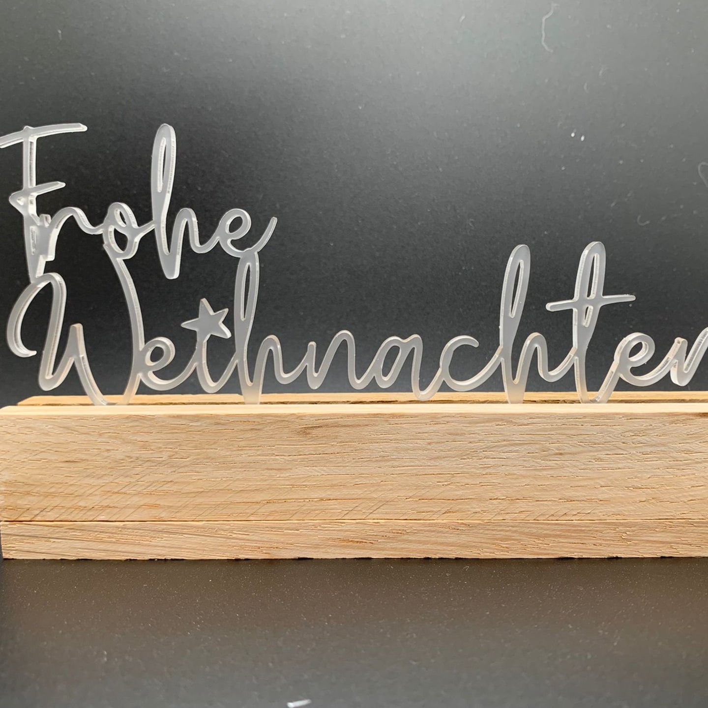 Dekorativer Easy-Sticks Aryl Aufsteller mit dem Schriftzug 'Frohe Weihnachten' auf einem Holzsockel, perfekt für festliche Dekorationen von Easy-Sticks.