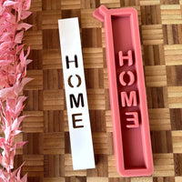 Silikonform 'HOME Schriftzug' von easy-sticks mit zwei Formen, einer weißen Form mit ausgeschnittenem Schriftzug und einer rosa Silikonform, ideal zum Gießen von Windlichtern und Dekorationen.
