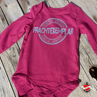 Ein kreatives babybody in einem tiefen Rubinrot mit dem Schriftzug 'Prachtexemplar' in einer limitierten Auflage im Design von easy-sticks. Ideal für kleine Trendsetter und kreative Eltern.