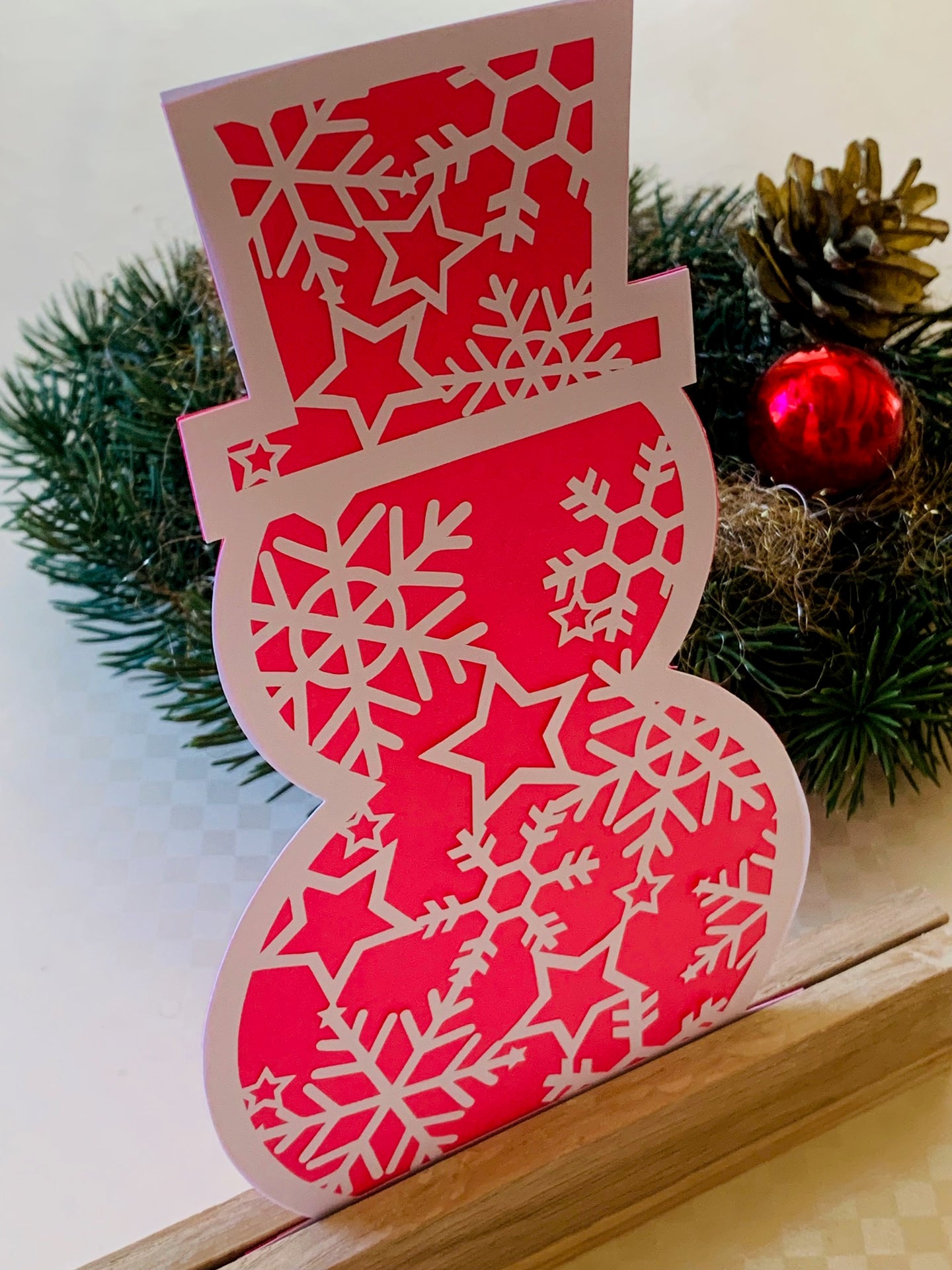 Kreative winterliche Dekoration mit einem pinken Schneemann, gefertigt aus Papier, ideal zum Basteln und Plotten. Entdecke die Schneemann Plotterdatei von easy-sticks für deine festlichen Projekte.