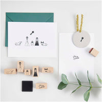 Das Stempelset "Krippe" von easy-sticks, bestehend aus 7 handgefertigten Stempeln, die die Weihnachtsgeschichte darstellen. Die Abbildung zeigt eine kreative Anordnung der Stempel, die Figuren wie Maria, Joseph, Ochse, Esel und einen Stern umfasst, zusammen mit Weihnachtskarten und einem Stempelkissen.