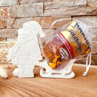 Weihnachtsmann mit Schlitten Silikonform von easy-sticks, präsentiert mit einer Tüte gefüllter Süßigkeiten für festliche Dekorationen.