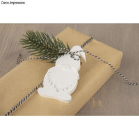 Geschenkverpackung mit Silikon Gießform Wichtel von easy-sticks, verziert mit einem weißen Wichtel und Tannenzweigen für eine kreative Weihnachtsgestaltung.