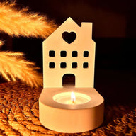 Ein stilvoller Teelichthalter in Form eines Hauses mit Herz von Easy-Sticks, beleuchtet von einer Kerze, bringt eine warme Atmosphäre in jeden Raum. Ideal für romantische Abende.