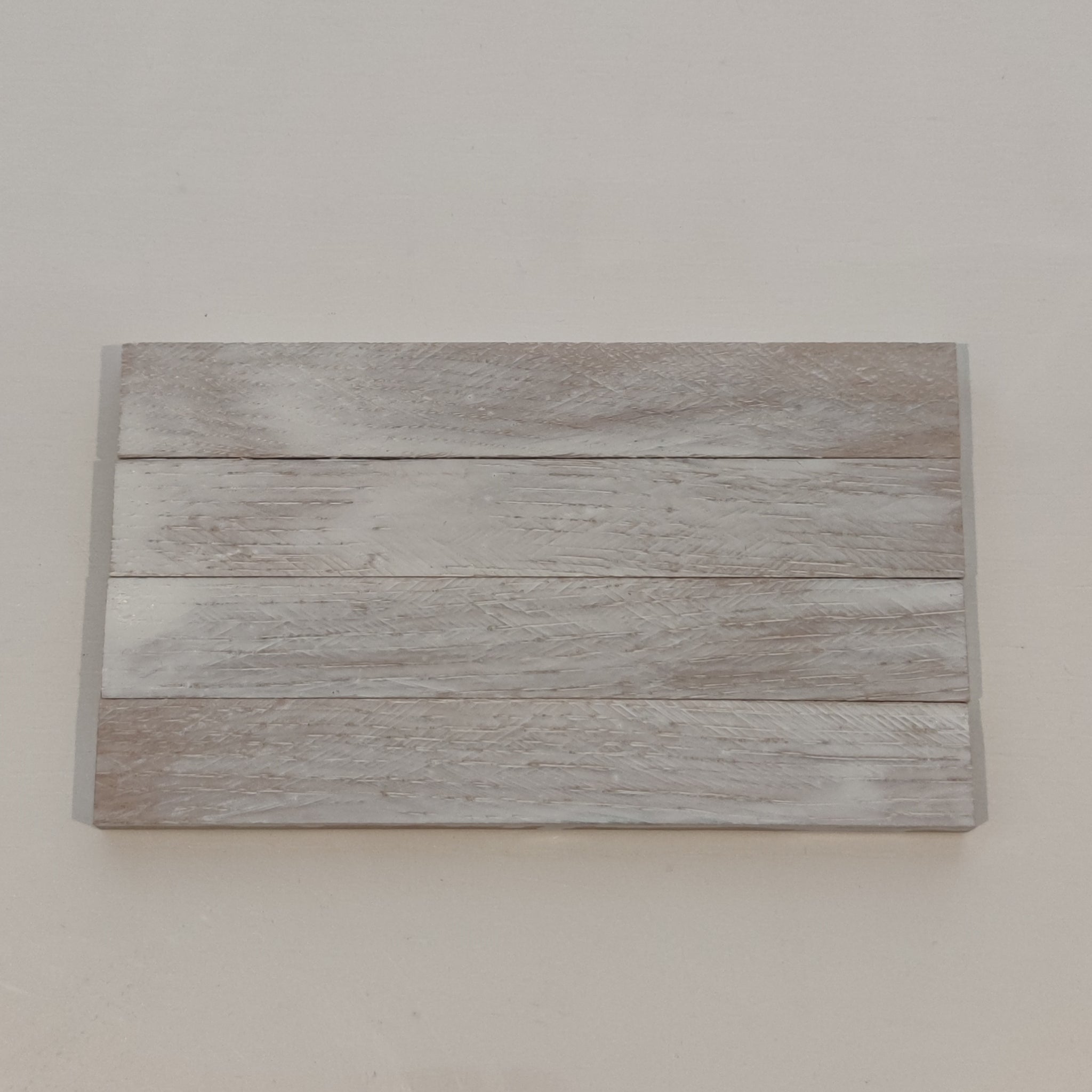 Behandelte Holzoberfläche in einem sanften Weiß-Grauton, veredelt mit Easy-Sticks Color Holzlasur Weiß Transparent, ideal für stilvolle Innenräume.