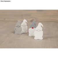 Dekorative Weihnachtswichtel aus der Silikon Gießform Wichtel von easy-sticks, präsentiert in verschiedenen Farben auf einem rustikalen Tisch.