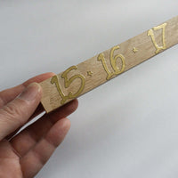 Nahaufnahme eines Adventszahlen Stickers mit den Zahlen 15, 16 und 17 in glänzendem Gold, gehalten in der Hand. Perfekt zur individuellen Gestaltung von Adventskalendern mit easy-sticks.