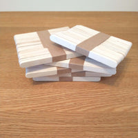 Die Verpackung von Easy-Sticks Ice von Easy-Sticks: Mehrere Stapel dünner Holzstäbchen, perfekt für Bastelideen, geordnet auf einem Holztisch.