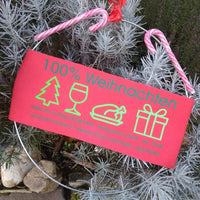 Bunte Dekoration mit der Aufschrift '100% Weihnachten', umgeben von Tannenzweigen; perfekt für festliche Bastelprojekte von easy-sticks.