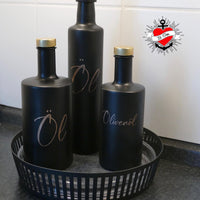 Elegante schwarze Ölflaschen mit goldenen Deckeln, beschriftet mit 'Öl' und 'Olivenöl', entwickelt von easy-sticks, passend zur Laserdatei '138 x Vorratshaltung'. Perfekt für kreative Aufbewahrungslösungen.