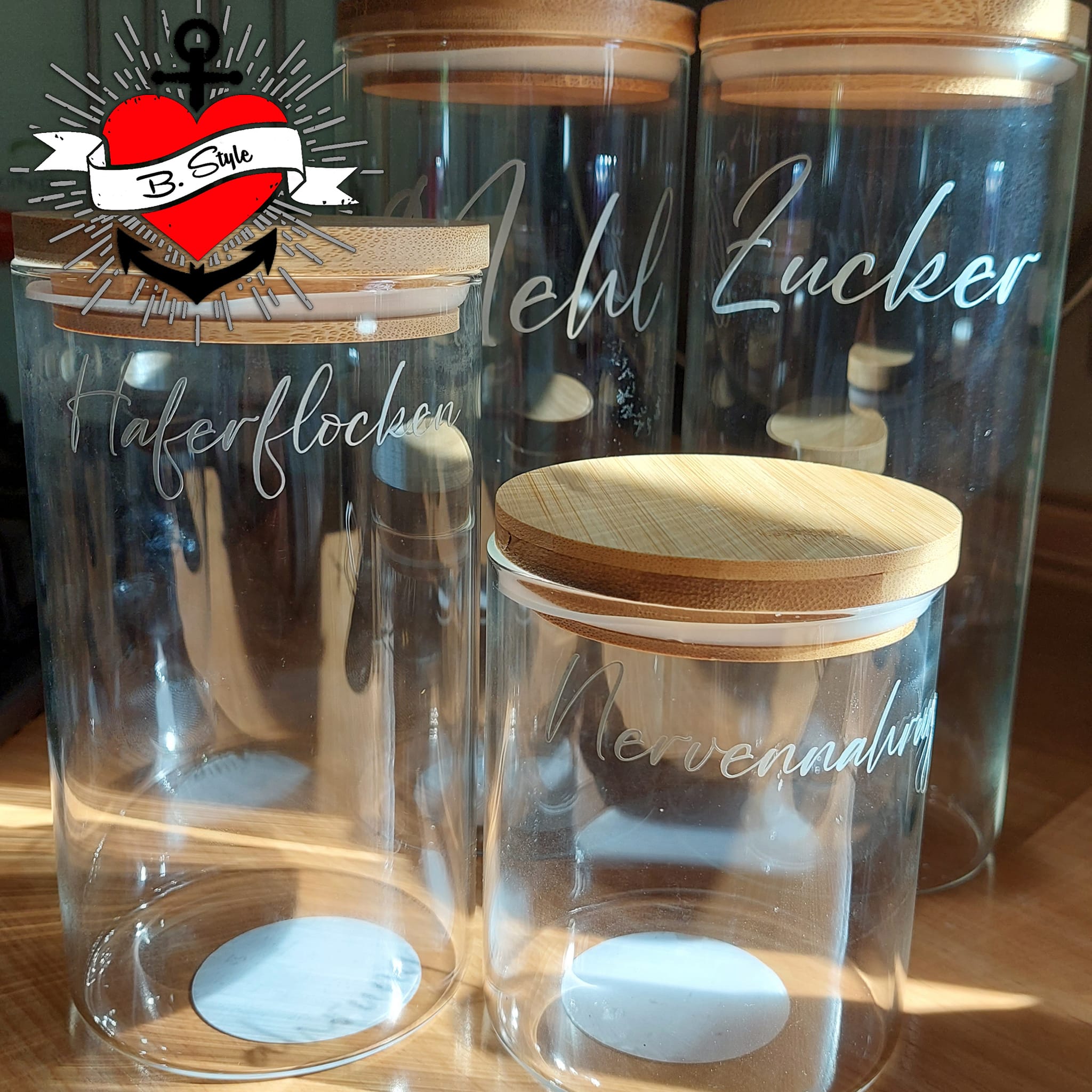 Transparente Aufbewahrungsgläser mit Holzkappen, individuell beschriftet mit Zutaten wie Haferflocken und Zucker. Eine kreative Lösung für Küchenelemente. Entdecke mehr mit der '138 x Vorratshaltung' Laserdatei von easy-sticks.