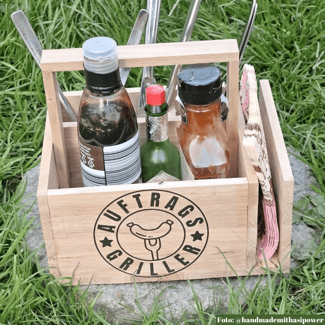 Personalisiertes Grillzubehör von easy-sticks: Holzkiste mit Grillutensilien und dem Design "Auftragsgriller" aus dem Grill Plotter Dateien Bundle.