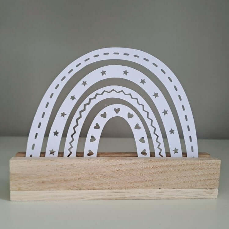 Elegante Regenbogenfigur in Weiß von easy-sticks, basierend auf der Regenbogen Plotter Datei, ideal als Geschenksidee oder Wohnaccessoire.