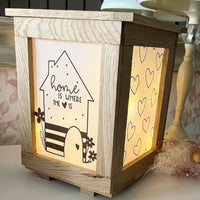 DIY Laterne mit Home-Motiv: "Home is where the heart is" von easy-sticks, strahlt warmes Licht durch die kunstvoll gestaltete Laterne mit Herzen und Blumen.