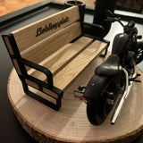 Detailaufnahme eines Bankhalters von easy-sticks mit einer Miniaturbank und einem Motorrad, schön platziert auf einem Holzuntergrund.