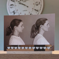 Ein Profilfoto einer Frau in schwarz-weiß, das elegant auf einem Holzständer platziert ist, dekoriert mit einem Herzen, gestylt mit Easy-Sticks Rub Ons A5, schwarz oder weiß.