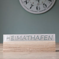 Stylisches Acrylschild mit dem Schriftzug "HEIMATHAFEN" von Easy-Sticks, auf einem Holzsockel, in zeitgemäßem Design.