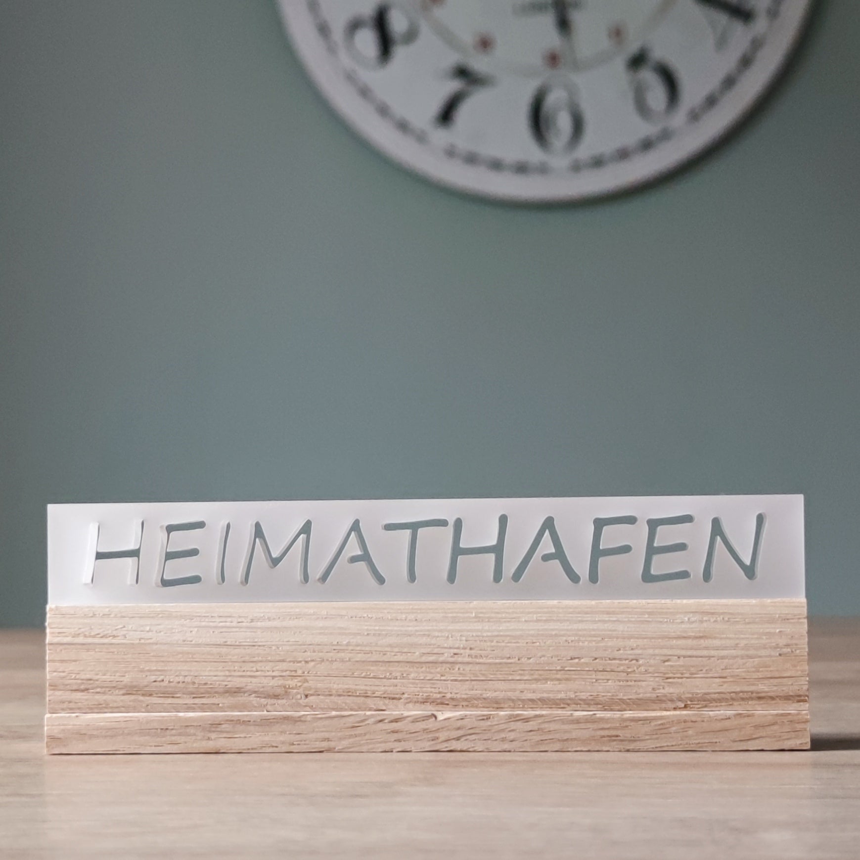Stylisches Acrylschild mit dem Schriftzug "HEIMATHAFEN" von Easy-Sticks, auf einem Holzsockel, in zeitgemäßem Design.