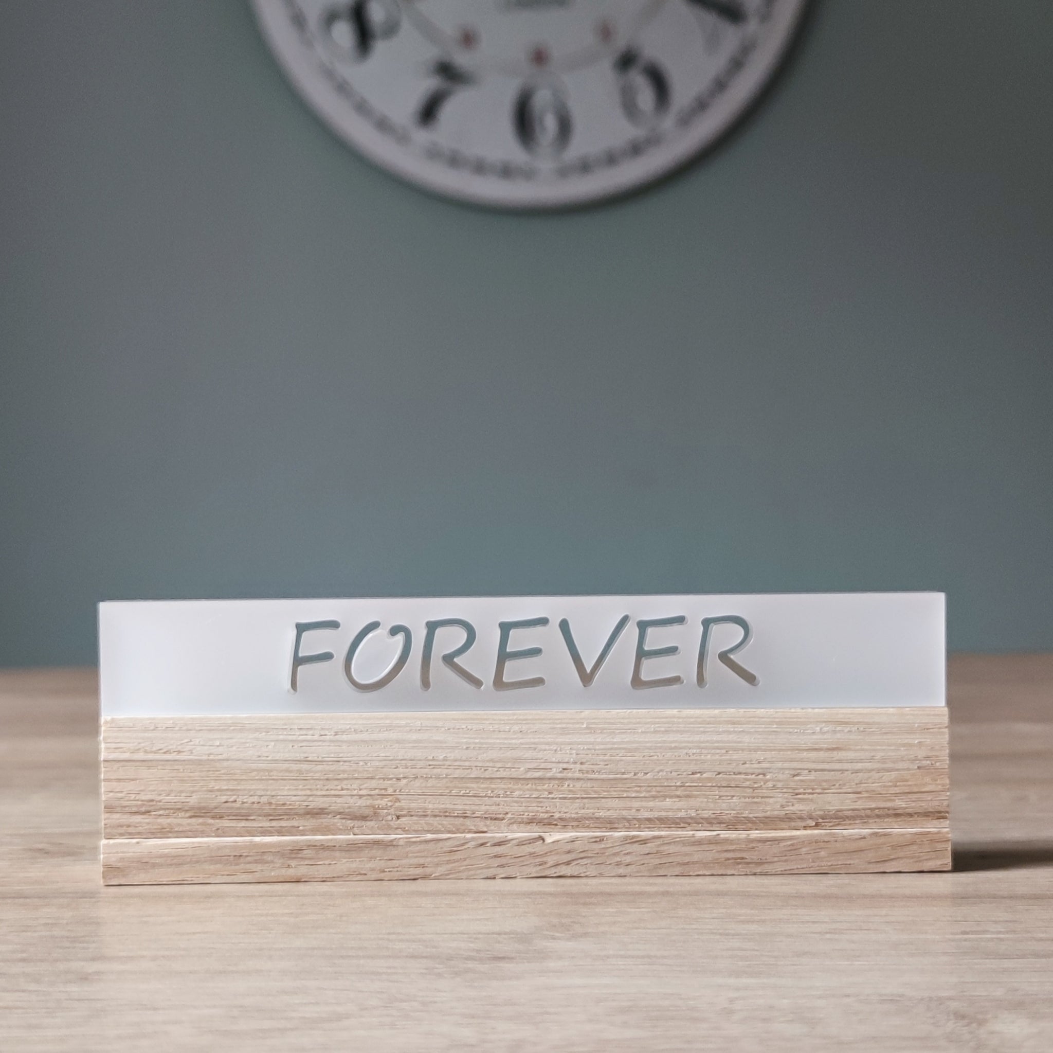 Elegantes Acrylschild 'FOREVER' auf einem Holzsockel, hergestellt von Easy-Sticks; ideal für romantische Anlässe oder als stilvolle Wohnraumdekoration.