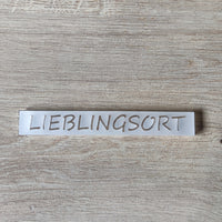 Nahaufnahme des Acrylsatzes "LIEBLINGSORT" von Easy-Sticks, der auf einer Holzoberfläche liegt.