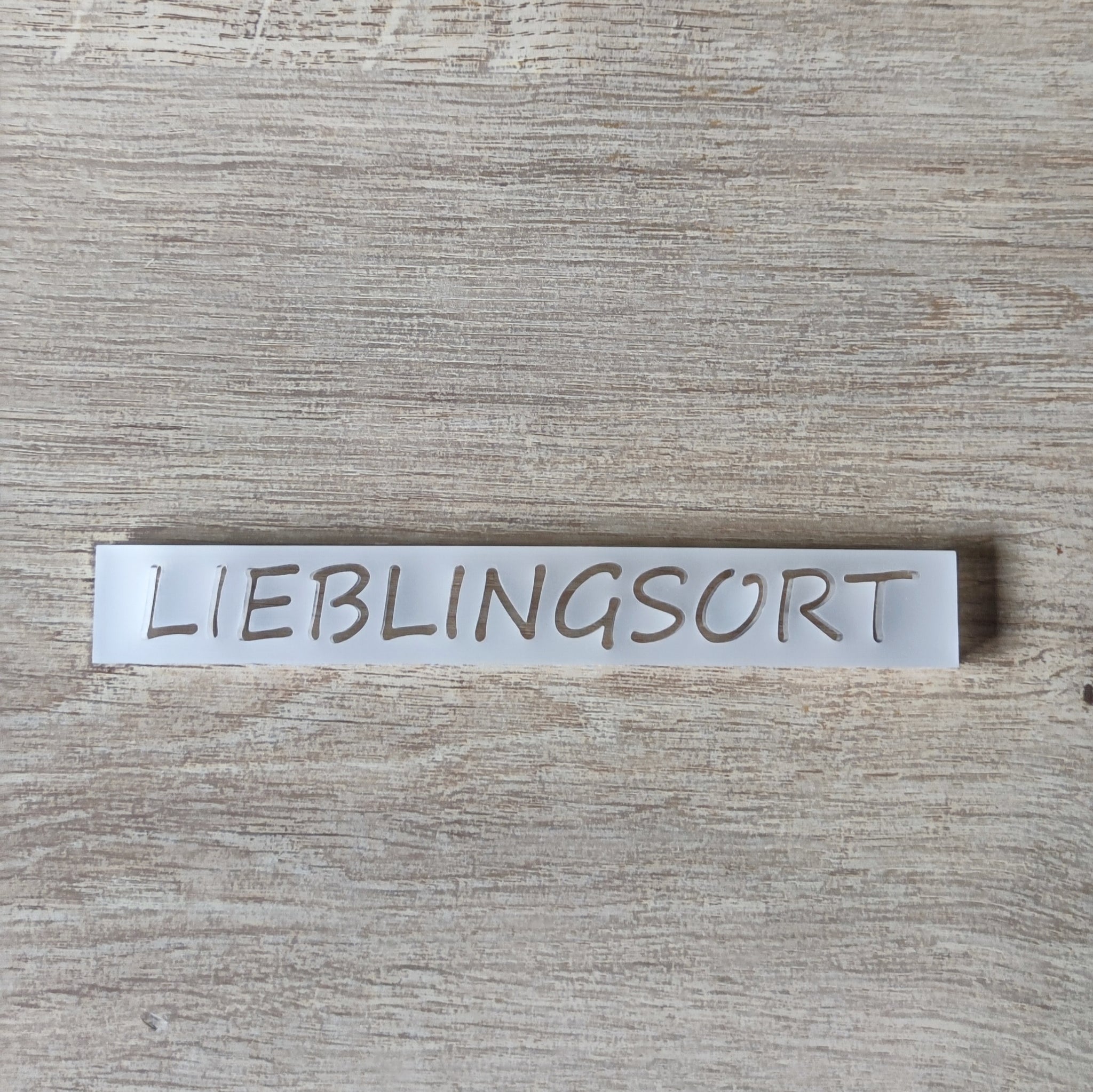 Nahaufnahme des Acrylsatzes "LIEBLINGSORT" von Easy-Sticks, der auf einer Holzoberfläche liegt.