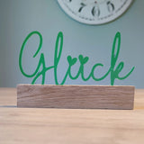 Ein stilvoller Acryl Aufsteller von Easy-Sticks mit der Aufschrift 'Glück' in leuchtendem Grün, ideal für eine einladende Dekoration in verschiedenen Räumen.