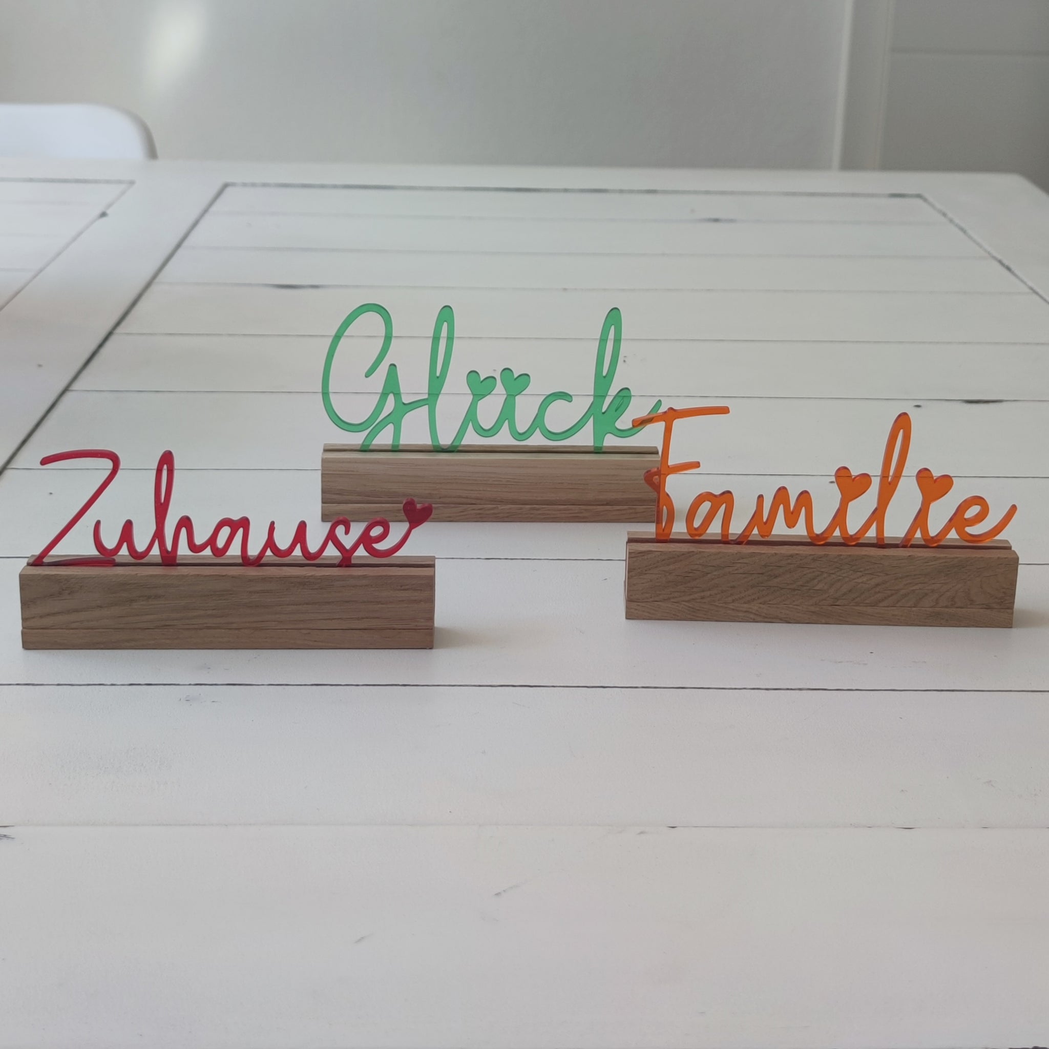 Dekorativer Acryl Aufsteller von Easy-Sticks mit dem Schriftzug 'Glück', umgeben von weiteren farbigen Wörtern, ideal für eine warme und einladende Atmosphäre.