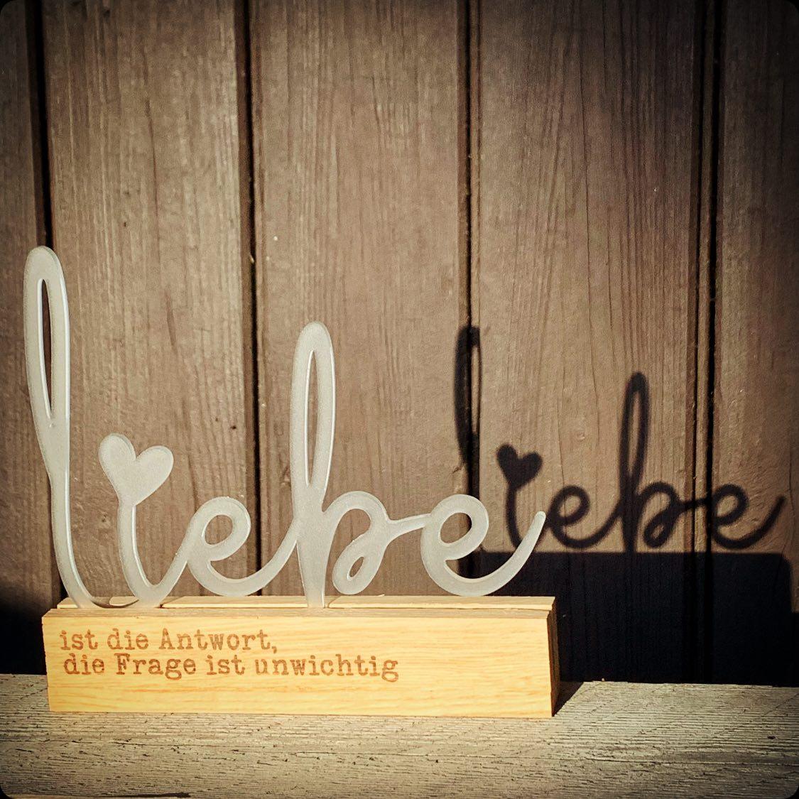 Eleganter Acryl Aufsteller "Liebe" von Easy-Sticks, dekorativ platziert mit warmem Holzsockel, ideal für eine liebevolle Atmosphäre in jedem Raum.