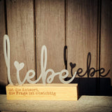 Eleganter Acryl Aufsteller "Liebe" von Easy-Sticks, dekorativ platziert mit warmem Holzsockel, ideal für eine liebevolle Atmosphäre in jedem Raum.
