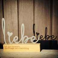 Eleganter Acryl Aufsteller "Liebe" von Easy-Sticks, dekorativ platziert mit warmem Holzsockel, ideal für eine liebevolle Atmosphäre in jedem Raum.