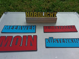 Schicke Plotter-Worte 'Nordlicht', 'Meerweh', 'Heimathafen', 'Moin' und 'Küstenkind' auf einem metallischen Untergrund, ein Design von easy-sticks.