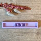 Detaillierte Ansicht der lila Easy-Sticks Silikonform 'Liebe', dekoriert mit sanften Trockenblumen auf einem holzigen Tisch.