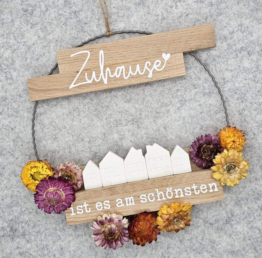Dekorativer Aufsteller mit dem Titel 'Sprüche für deinen "Zuhause" Acryl Aufsteller zum Plotten und Lasern' von easy-sticks, verziert mit bunten Trockenblumen und einem Holzrahmen, der den Spruch 'ist es am schönsten' hervorhebt.