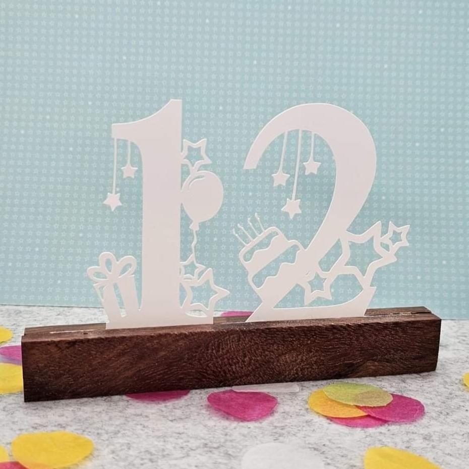 Schöner Geburtstags Aufsteller mit den Zahlen 12, ergänzt mit einem von bunten Konfetti umgebenen design von easy-sticks.