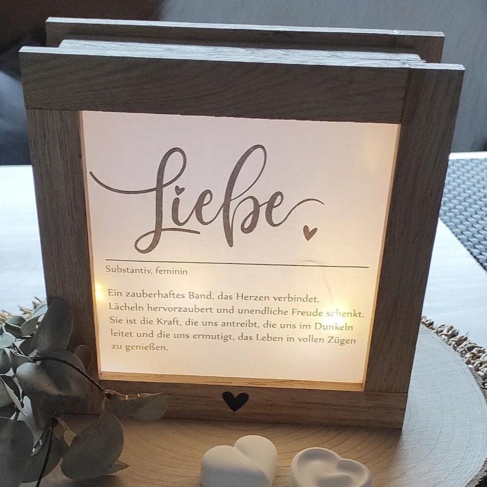 Elegante Laterne mit dem Wort 'Liebe', aus Holz gefertigt und beleuchtet. Perfekt für Bastelfreunde, die die LIEBE Laterne und Lichtbox Bastel PDF von easy-sticks nutzen, um individuelle Deko zu gestalten.