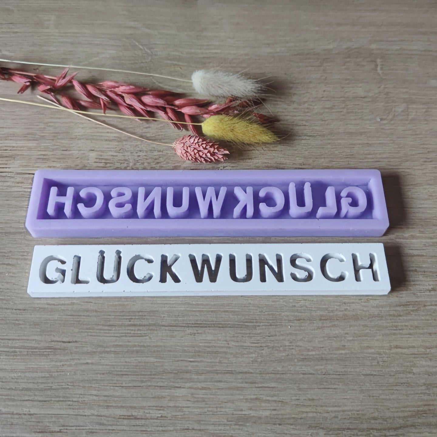 Silikonform von Easy-Sticks mit dem Schriftzug 'GLÜCKWUNSCH', ideal für kreative Bastelprojekte. Die Form ist in lila und zeigt die Detailgenauigkeit in der Verarbeitung.